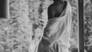 Femme élégante en robe claire près dune fenêtre