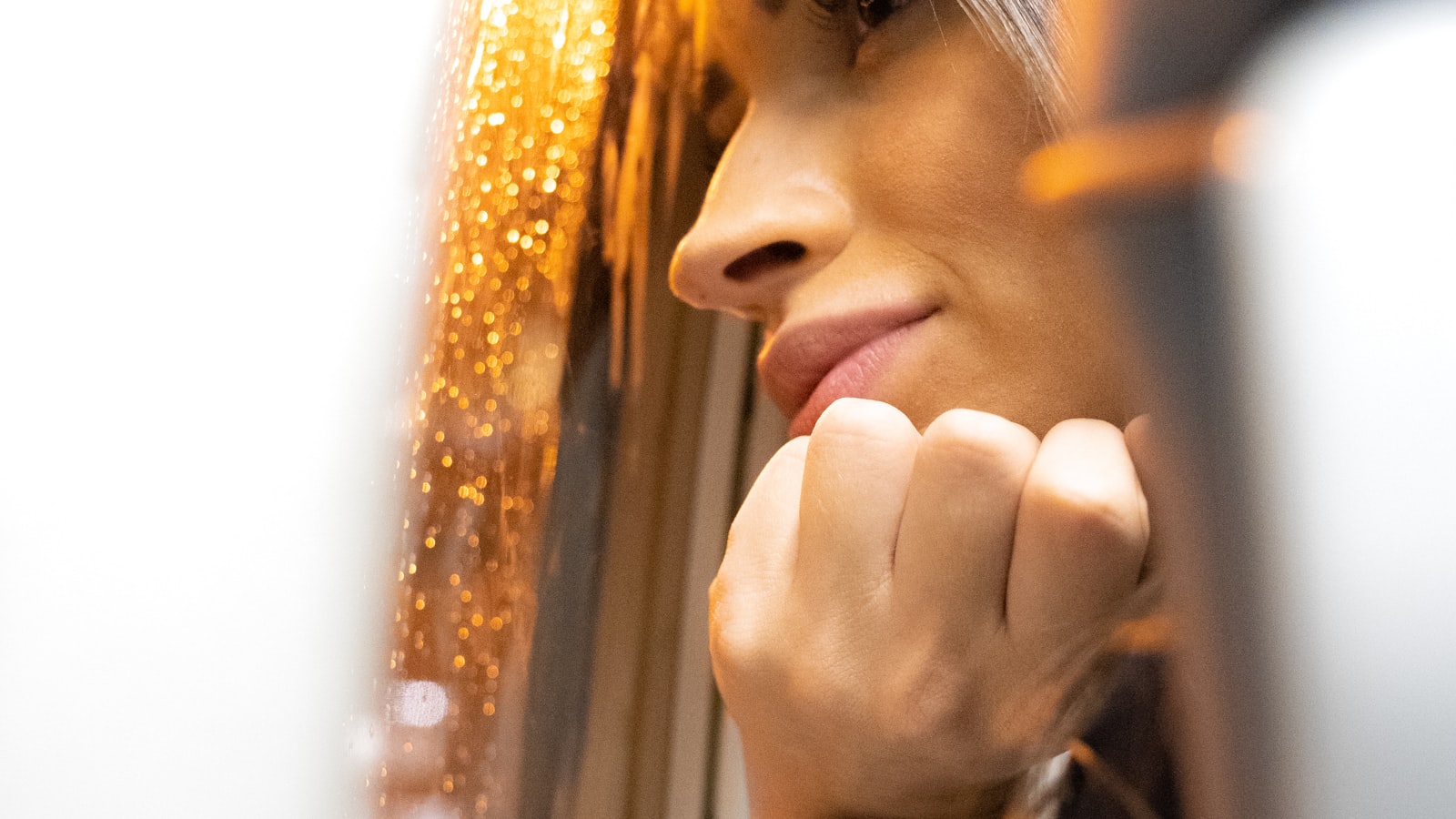 Femme pensive à la fenêtre dun intérieur soigné